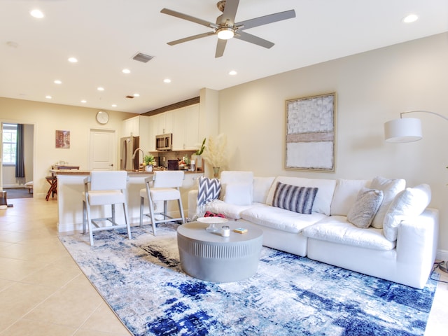 living room featuring sink, ceiling fan, and light tile patterned flooring