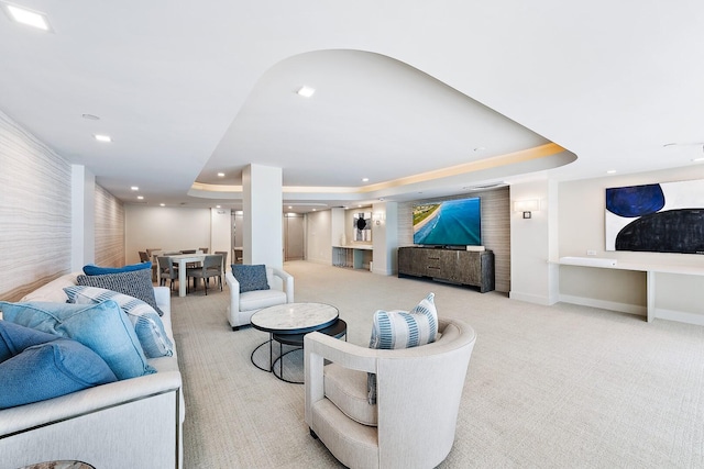 carpeted living room with a tray ceiling