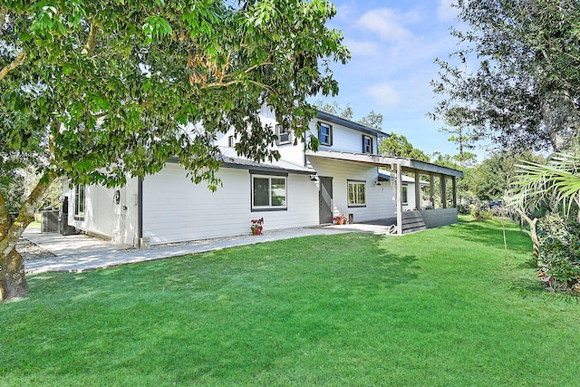 back of property with a patio area and a yard