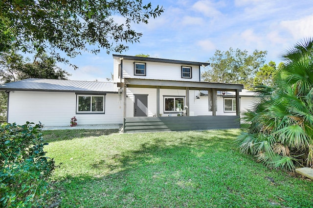 rear view of property featuring a lawn