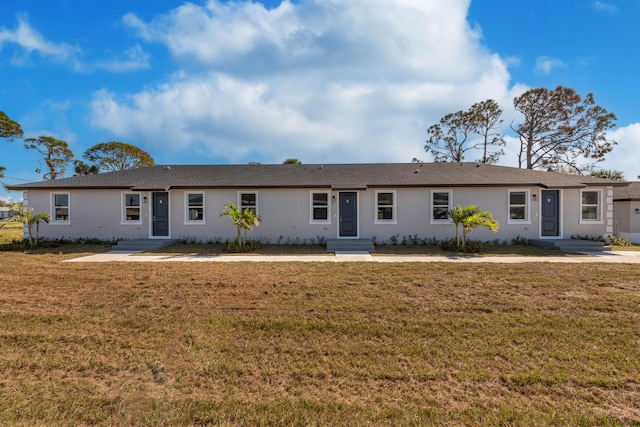 view of front facade with stucco siding and a front lawn