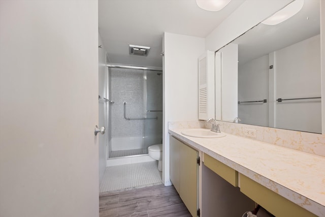 bathroom featuring tile patterned floors, vanity, a shower with shower door, and toilet