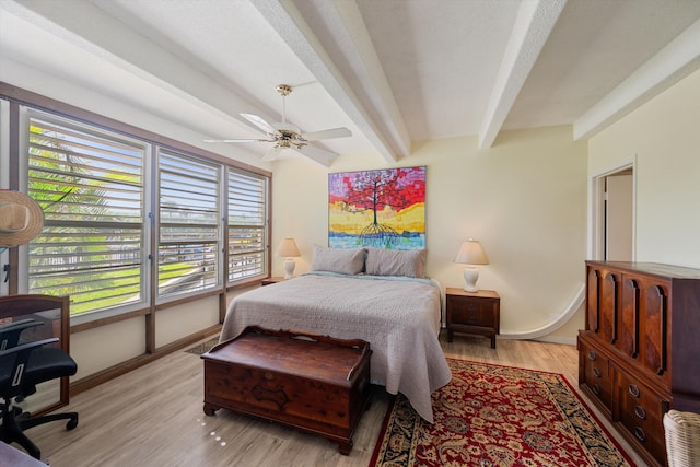 bedroom featuring ceiling fan, beamed ceiling, and light hardwood / wood-style floors