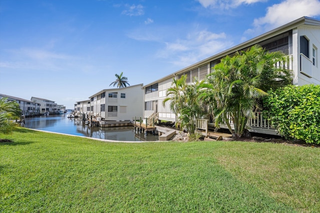 dock area with a lawn and a water view