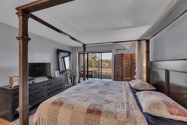 bedroom with access to outside and a textured ceiling