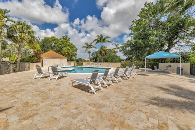 view of swimming pool with a patio and an outbuilding