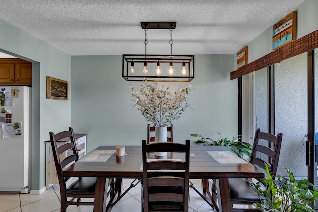 dining room featuring a textured ceiling and light tile patterned floors