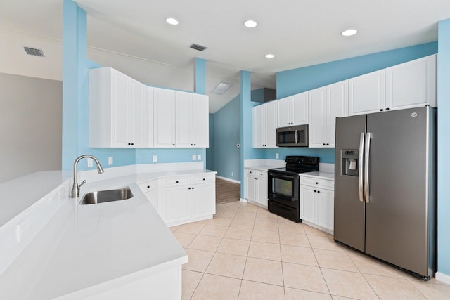 kitchen featuring lofted ceiling, light tile patterned floors, white cabinetry, sink, and stainless steel appliances