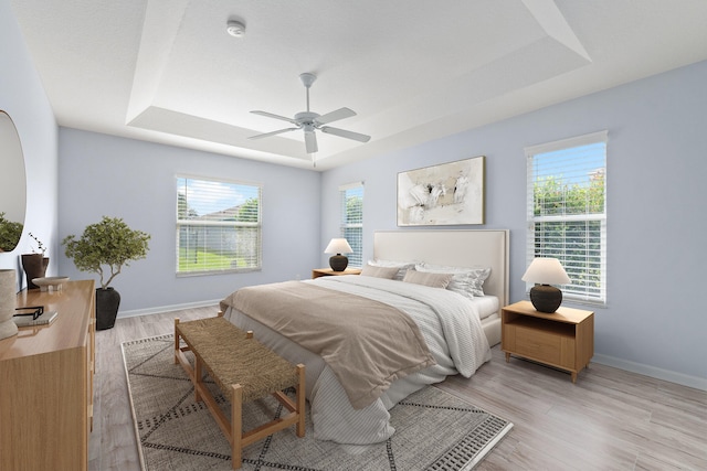 bedroom featuring light hardwood / wood-style flooring, multiple windows, and ceiling fan