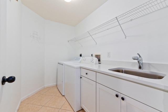 laundry room with cabinets, sink, washing machine and clothes dryer, and light tile patterned floors