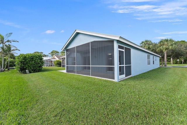 back of house with a yard and a sunroom