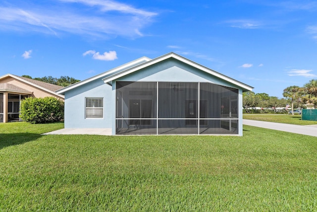 rear view of property featuring a sunroom and a lawn