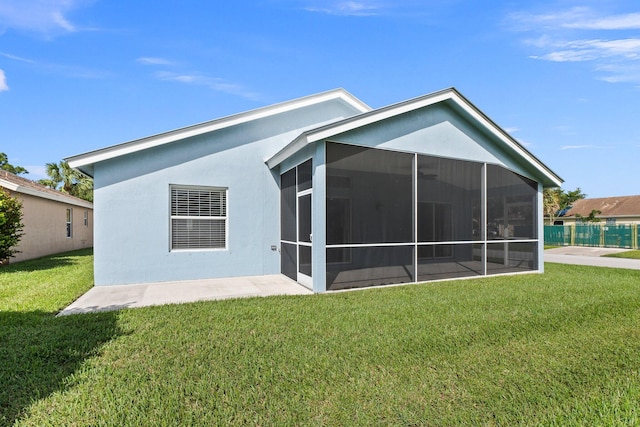 rear view of property with a lawn and a sunroom