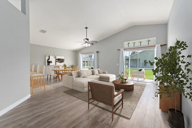 living room with lofted ceiling, light hardwood / wood-style flooring, and ceiling fan