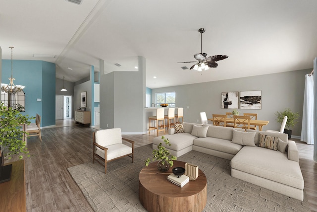 living room featuring hardwood / wood-style flooring, ceiling fan with notable chandelier, and vaulted ceiling