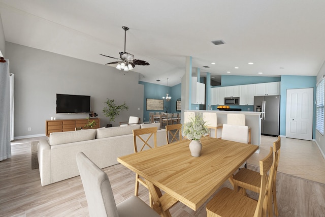 dining space featuring light hardwood / wood-style floors, lofted ceiling, and ceiling fan with notable chandelier