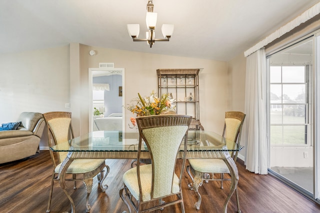 dining space with lofted ceiling, a notable chandelier, and dark hardwood / wood-style floors