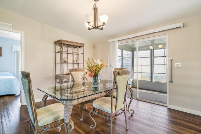 dining area featuring an inviting chandelier, vaulted ceiling, and dark hardwood / wood-style flooring