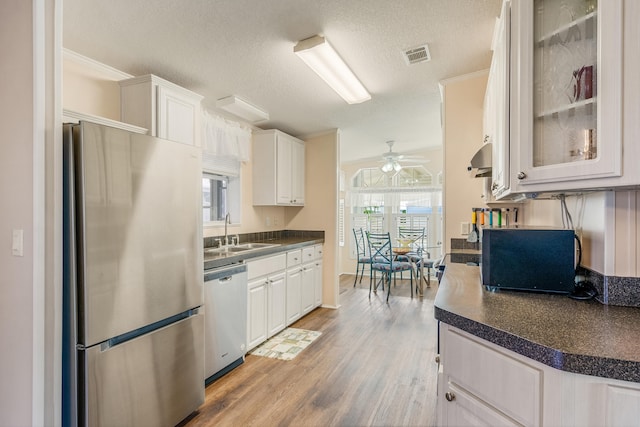 kitchen featuring sink, appliances with stainless steel finishes, white cabinetry, and plenty of natural light