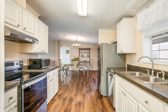 kitchen with white cabinetry, stainless steel appliances, sink, and vaulted ceiling