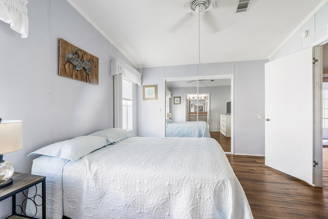 bedroom with ornamental molding, ceiling fan, a closet, and dark hardwood / wood-style flooring