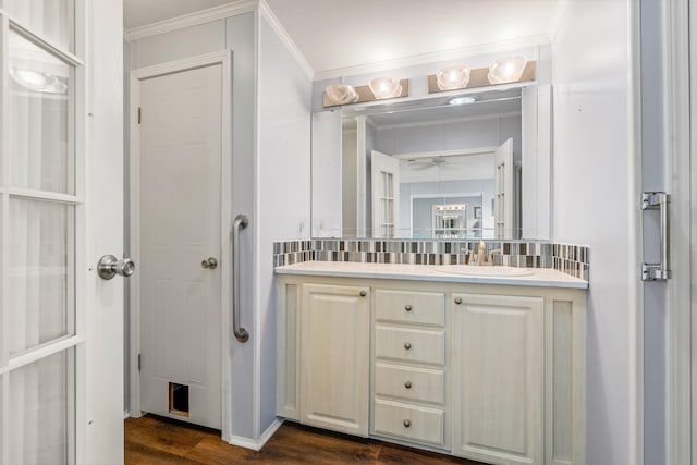 bathroom with vanity, ornamental molding, decorative backsplash, and hardwood / wood-style floors