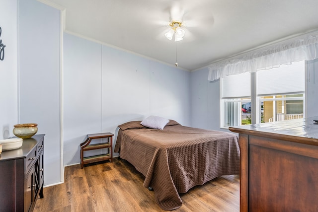 bedroom with ornamental molding, ceiling fan, and dark hardwood / wood-style flooring