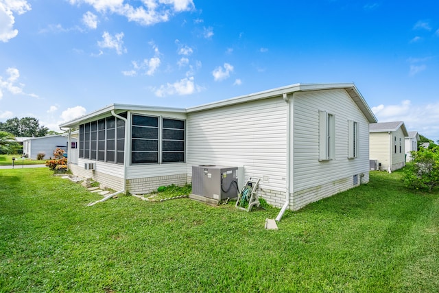 view of side of property with cooling unit and a lawn