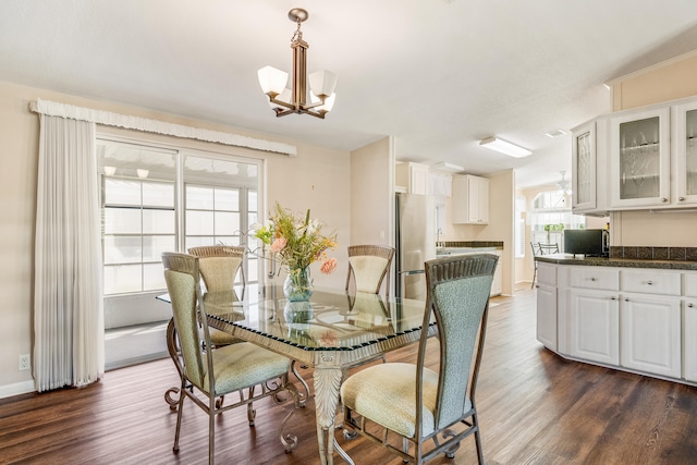 dining room featuring a chandelier, dark hardwood / wood-style floors, and a healthy amount of sunlight