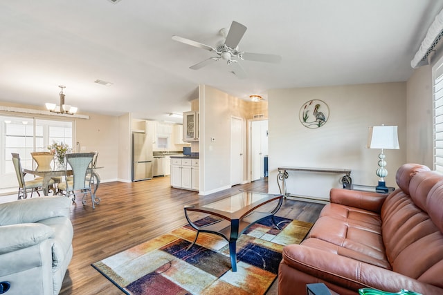 living room featuring light hardwood / wood-style floors and ceiling fan with notable chandelier