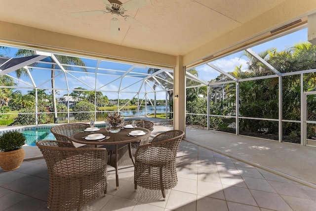 view of patio / terrace with a water view, ceiling fan, a lanai, and an outdoor pool