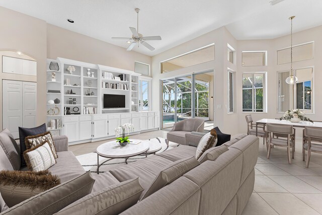 8037 SE Woodlake Ln, Hobe Sound, FL 33455 - living room featuring crown molding, light tile patterned flooring, a fireplace, and arched walkways