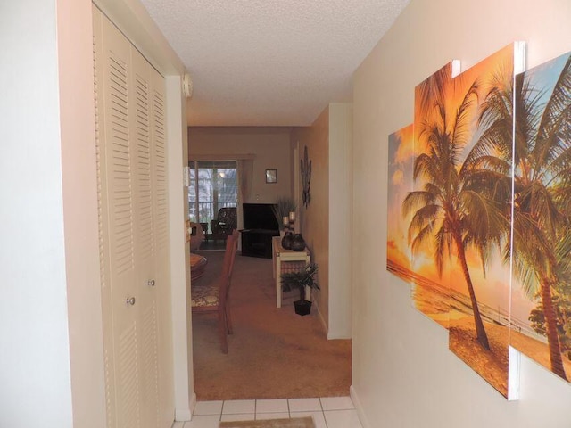 hall with light tile patterned flooring and a textured ceiling