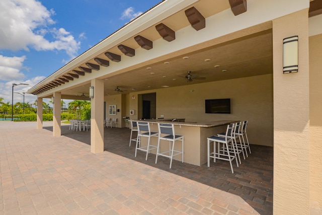 view of patio / terrace featuring an outdoor bar and ceiling fan