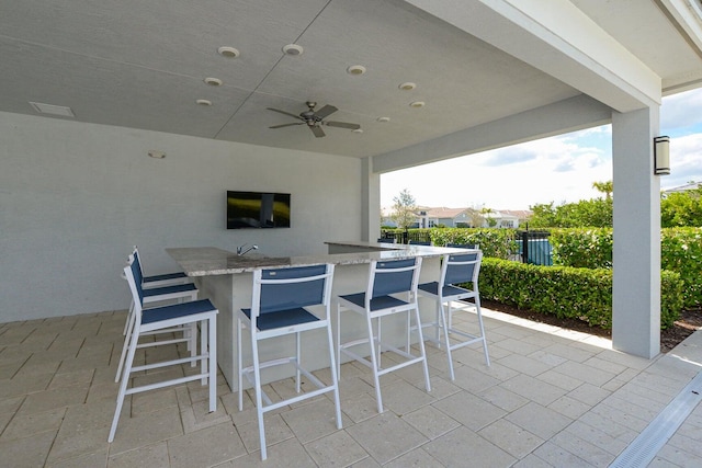 view of patio / terrace with an outdoor bar, an outdoor kitchen, and ceiling fan