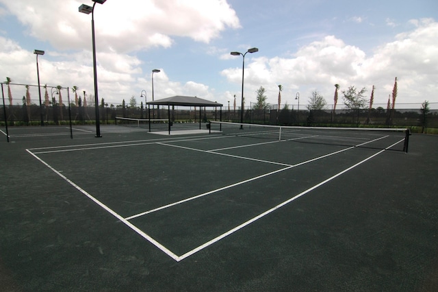 view of tennis court featuring fence