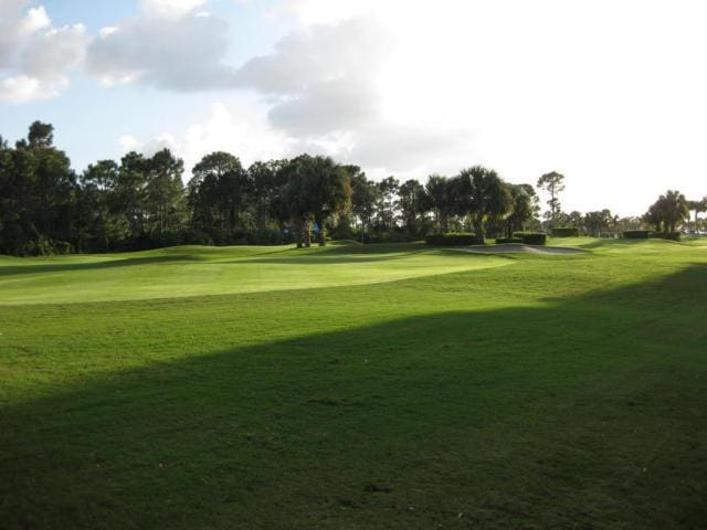 view of home's community featuring view of golf course and a lawn