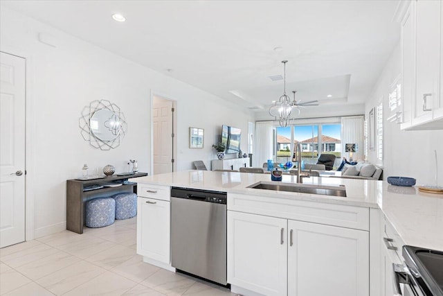 kitchen featuring white cabinetry, a peninsula, stainless steel appliances, and a tray ceiling
