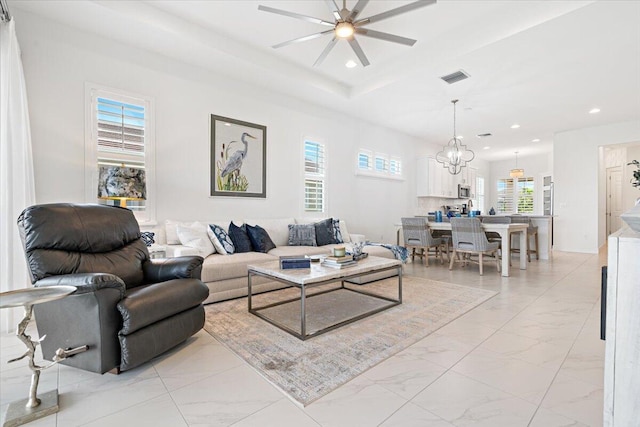 living area with visible vents, recessed lighting, marble finish floor, and ceiling fan with notable chandelier