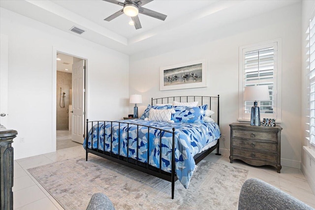 tiled bedroom with connected bathroom, visible vents, multiple windows, and baseboards