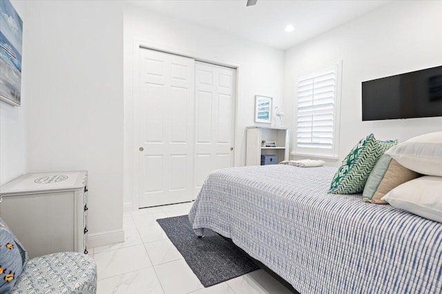 bedroom with baseboards, recessed lighting, a closet, and marble finish floor