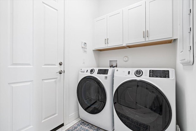 clothes washing area featuring light tile patterned floors, cabinet space, independent washer and dryer, and baseboards
