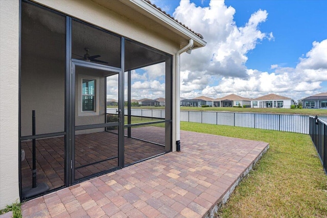 view of patio / terrace featuring a fenced backyard, a residential view, a water view, and a sunroom