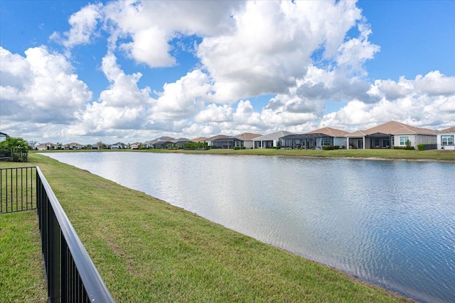 property view of water featuring fence and a residential view