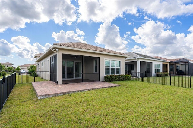 rear view of house featuring a fenced backyard, ceiling fan, a patio, a tile roof, and a lawn
