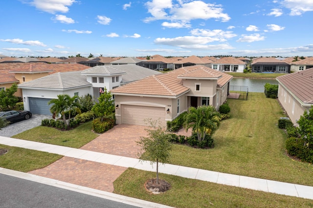 view of front of home with a front yard, a garage, and a water view