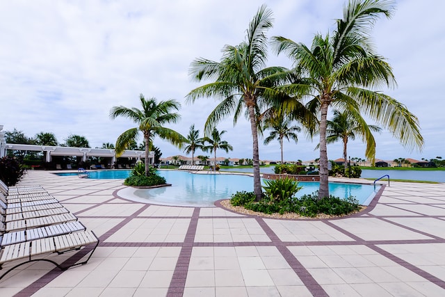 view of swimming pool with a patio area and a water view