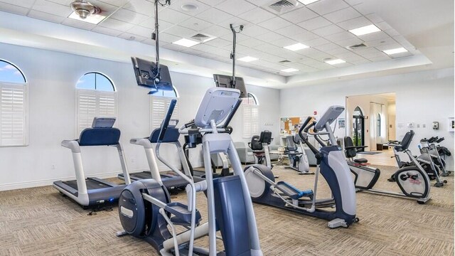 workout area featuring baseboards, visible vents, light colored carpet, and a drop ceiling