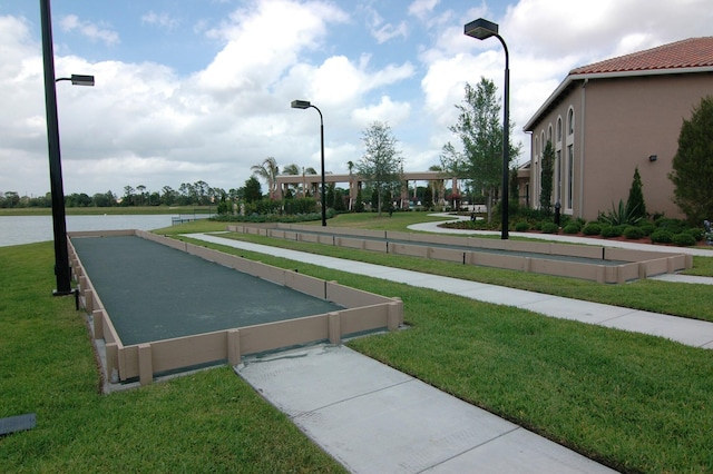 view of community with a water view and a yard
