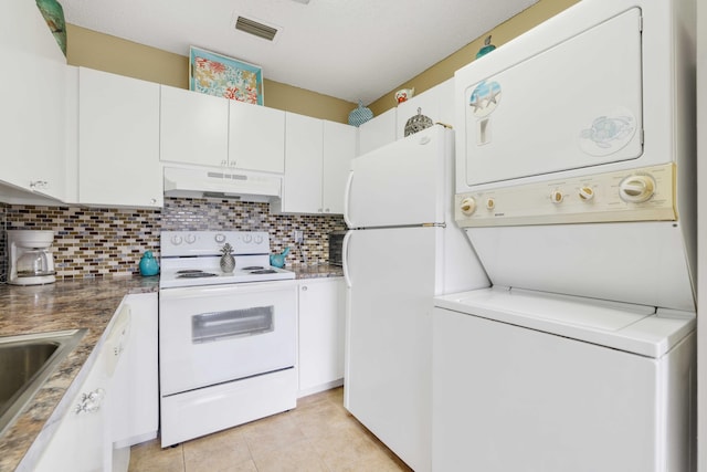 kitchen featuring tasteful backsplash, stacked washer / drying machine, white cabinets, and white appliances